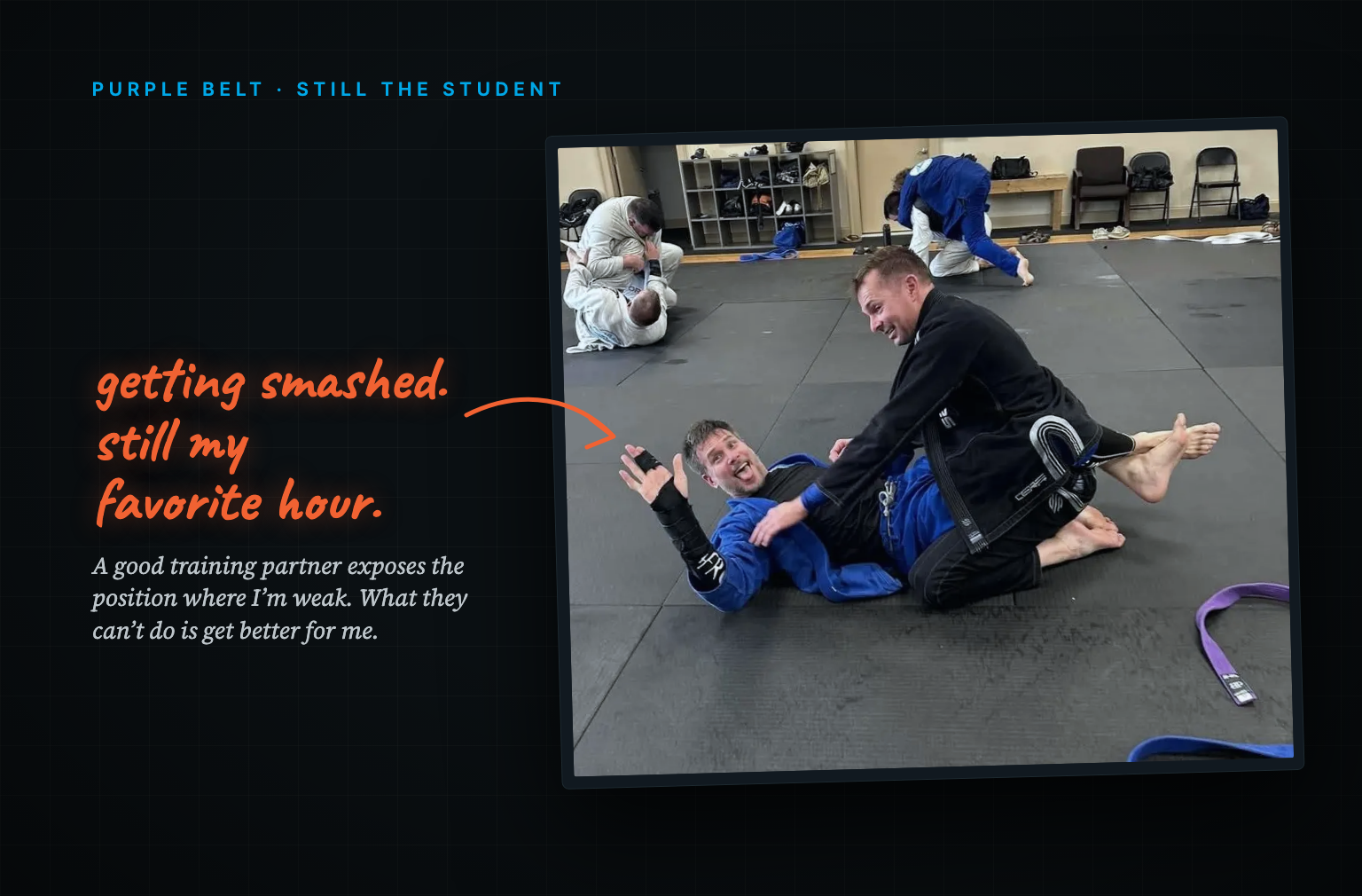 Tim laughing flat on his back while a training partner works to pass his guard on the jiu-jitsu mats, other pairs rolling behind them.
