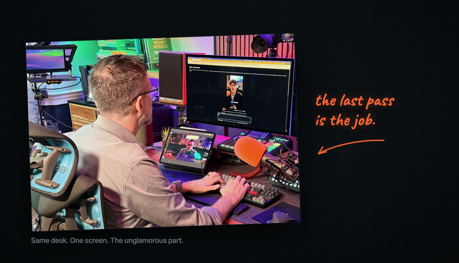 Tim at his desk from behind, hands on the keyboard, working on a single monitor in a room lit by coloured practicals.
